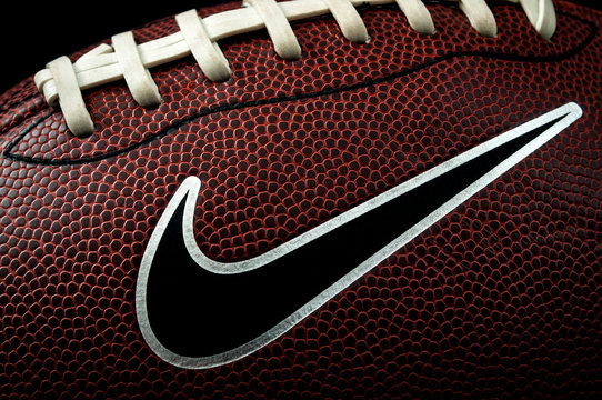 London, UK - 12th January 2018:Illustrative editorial of a macro image of a american football ball with visible laces, stitches, pigskin pattern and the nike logo with dramatic lighting