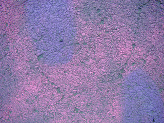 Wall of asphalt painted in crimson and lilac color. Abstraction for the background.