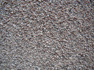Wall of small stones for the background. Color - shades of gray and brown.