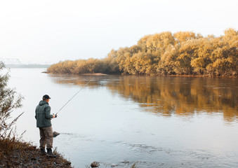 Obraz na płótnie Canvas A man is fishing on the river. Fisherman on a morning fishing trip