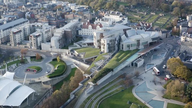 Flying directly over the Holyrood Scottish Parliament building and gardens | Edinburgh, Scotland | 4K at 30fps