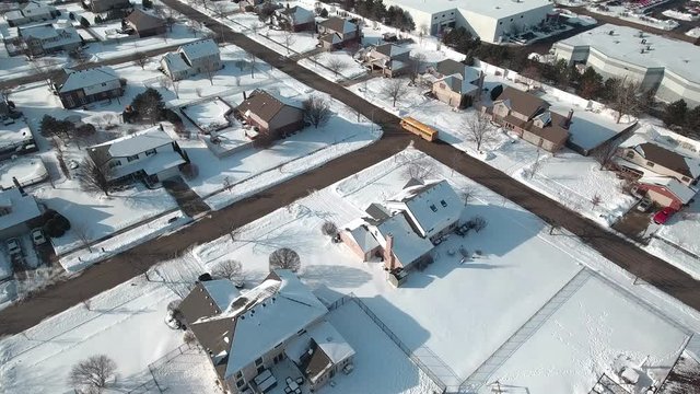 Aerial school bus driving children home from school on a cold winters day