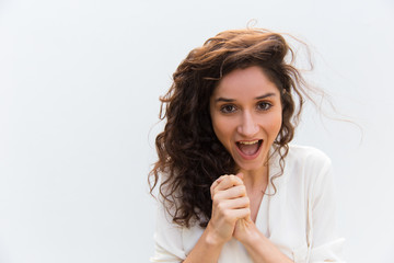 Successful young woman holding hands together. Happe curly lady looking at camera. Success concept