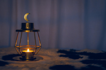 Modern golden lantern that have moon symbol on top with dark background for the Muslim feast of the holy month of Ramadan Kareem.
