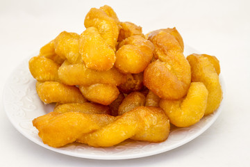 Koeksisters are traditional Afrikaner confectionery made of fried dough infused in syrup or honey isolated on a white background in horizontal format with copy space