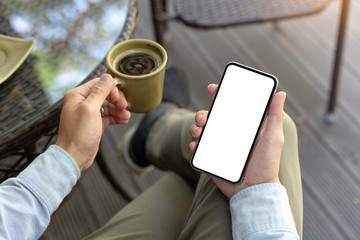 Mockup image blank white screen cell phone.man hand holding texting using mobile on desk at coffee shop.background empty space for advertise text.people contact marketing business,technology