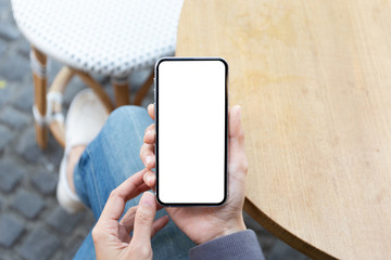 Mockup image blank white screen cell phone.woman hand holding texting using mobile on desk at coffee shop.background empty space for advertise text.people contact marketing business,technology
