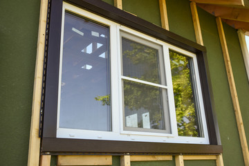 Wall covering of the frame house with panels of vinyl siding. construction or reconstruction, repair of the house. Installation of plastic Windows in a new residential building.