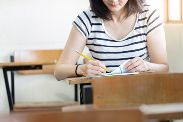 high school,university student study.hands holding pencil writing paper answer sheet.sitting lecture chair taking final exam attending in examination classroom.concept scholarship for education abroad