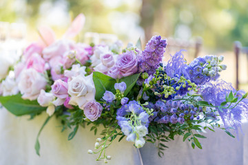 Obraz premium Bouquets of fresh flowers decoration of the festive table. Celebrating an open air party. Decor Details