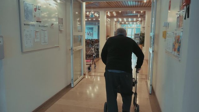 Alter Mann im Altersheim l&auml;uft am Rollator