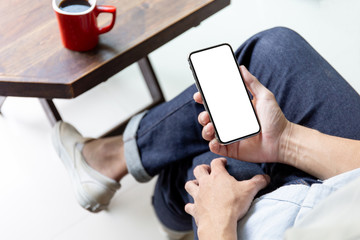 Mockup image blank white screen cell phone.man hand holding texting using mobile on desk at coffee shop.background empty space for advertise text.people contact marketing business,technology