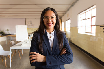 Confident smiling Asian businesswoman with crossed arms. Beautiful young woman in eyeglasses...