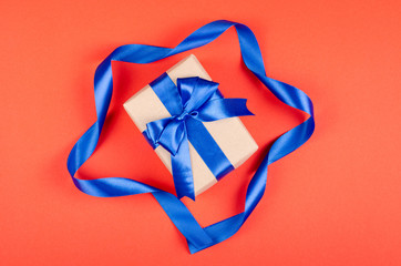 Gift box on red background composition, present with ribbon and bow.