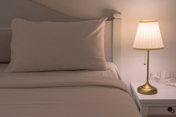 Bedside with a low energy side lamp turned on. The modern design.