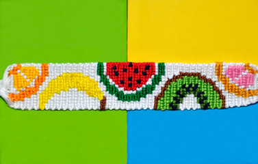 Fruit pattern of braided bracelet handmade of thread on bright three colors background