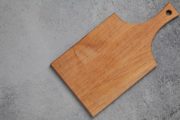 Wooden cutting board on grey stone table. Cutting board on kitchen table. Top view copy space. 