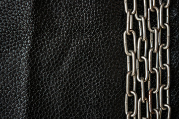 metal chain on a dark leather background.