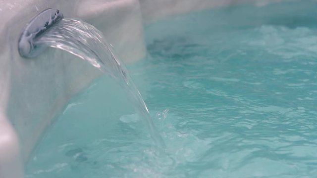 A current streams from a hot tub jet as the jacuzzi bubbles and froths.