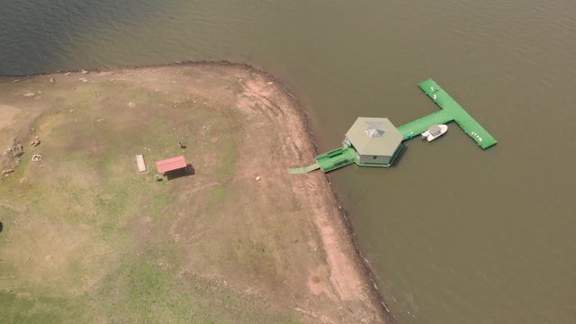 Aerial footage circling a dock on the edge of Tomin&eacute; reservoir