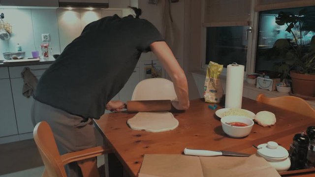 Mutter rollt Pizzateig in der K&uuml;che