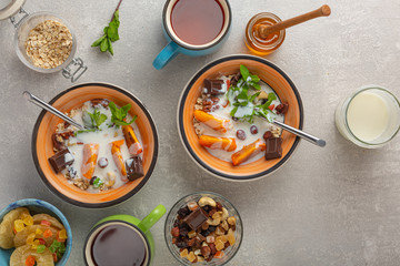 Breakfast of cereal and fruit. Cooking on gray concrete