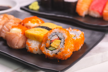 Sushi Roll with salmon, sushi maki roll and tamago sushi on black plate