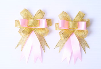 Bow. Golden and pink satin gift bow. Ribbon. Isolated on white