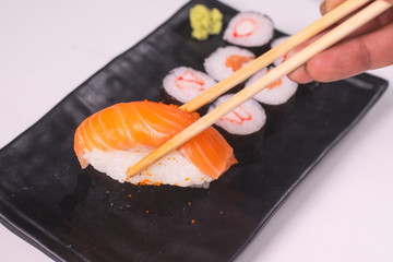 CloseUp Salmon sushi on a black plate. With wasabi and shoyu sauce. Focus salmon sushi.