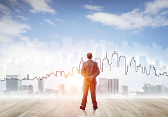 Motivation and inspiration concept with modern cityscape and businessman observing it