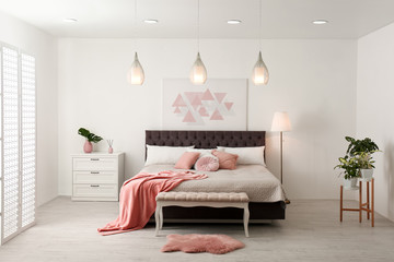 Stylish room interior with large comfortable bed
