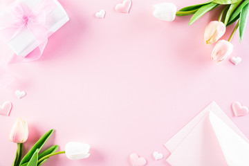 International Women's Day concept. Pink and white tulips with gift box and paper tag text on pink pastel background. Top view flat lay, March 8.