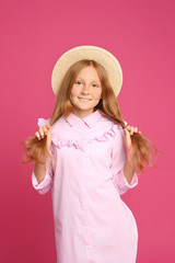 Portrait of preteen girl in hat on pink background