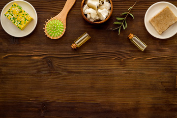 Hair care concept. Coconut oil, brush on dark wooden background top-down frame copy space