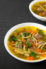 Homemade Sopa a La Minuta in white bowls on a black background, side view. Copy space.