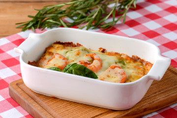 Piece of tomato lasagna in a white bowl. Dinner in a restaurant, cafe or diner. Healthy food, eating concept