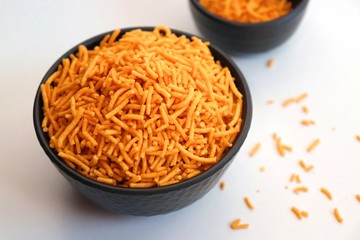 Aloo bhujia sev also known as Bikaneri Namkeen Sev is a popular crispy fried snack prepared by using Potatoes, Chickpea or Gram flour and spices. Its a best tea time snack. Copy space