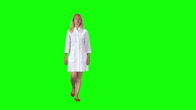 Blonde girl in a white medical coat going against a green screen.