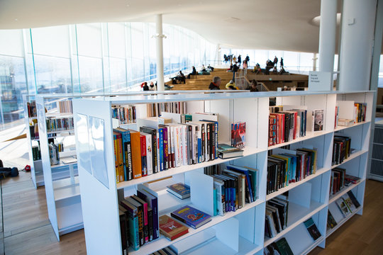 Helsinki, Finland- March 22 2019: New Helsinki central library Oodi interior. Light and spacious modern northern architecture. Bookshelves, working space. People reading, working, relaxing, studying. 