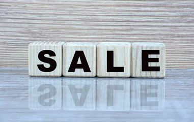 concept word sale on cubes with a mirror image on a grey shiny background