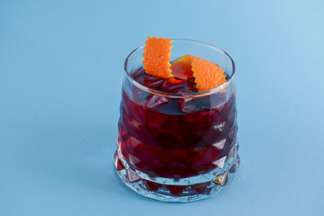 Fruit summer cocktail alcohol drink with ice and orange peel.