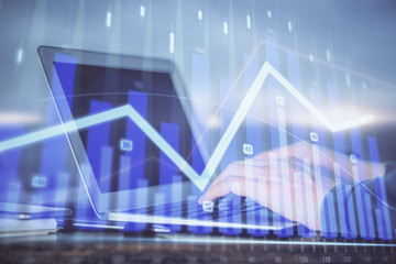 Double exposure of stock market graph with man working on laptop on background. Concept of financial analysis.
