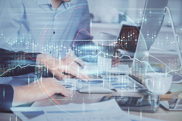 Multi exposure of chart with man typing on computer in office on background. Concept of hard work.