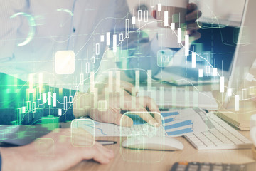 Multi exposure of chart with man typing on computer in office on background. Concept of hard work.