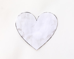 Watercolour splashes heart on white paper background.