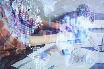 Double exposure of stock graph with businessman typing on computer in office on background. Concept of hard work.