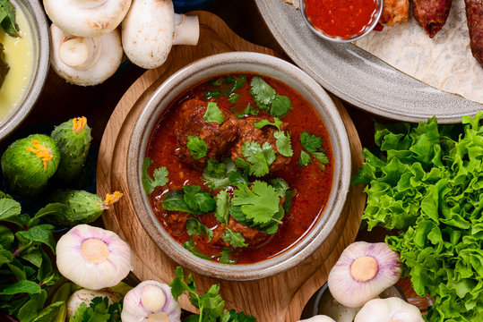 Traditional Georgian cuisine Top View. Khash Chikhirtma Harcho Soup, Dolma, Chanakhi, Chashululi, Chkmeruli, Kupati.