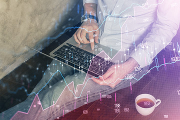 Forex graph with businessman working on computer in office on background. Concept of analysis. Double exposure.
