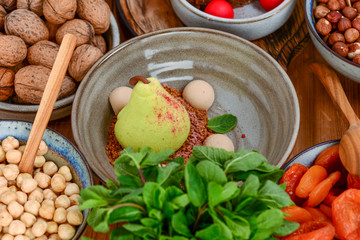 White chocolate pear fruit with cookies and mint leaves and nuts served in a bowl. Traditional Georgian dessert