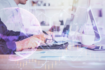 Forex graph with businessman working on computer in office on background. Concept of hardworking. Closeup. Multi exposure.